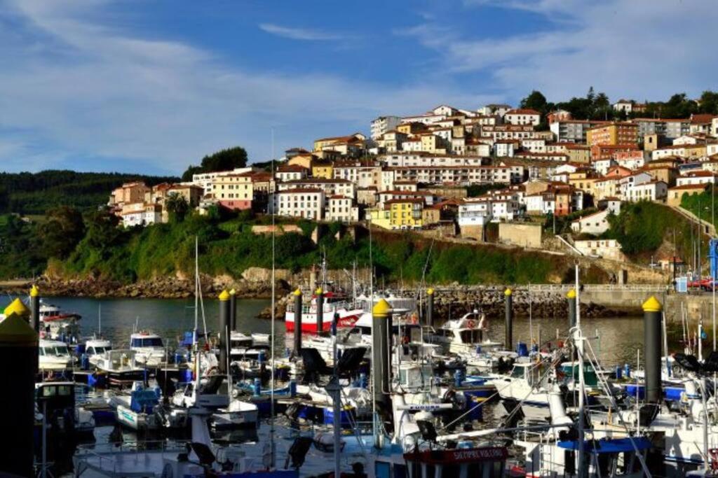 a bunch of boats docked in a harbor with a town at Casa barrio el Reloj - Lastres in Lastres