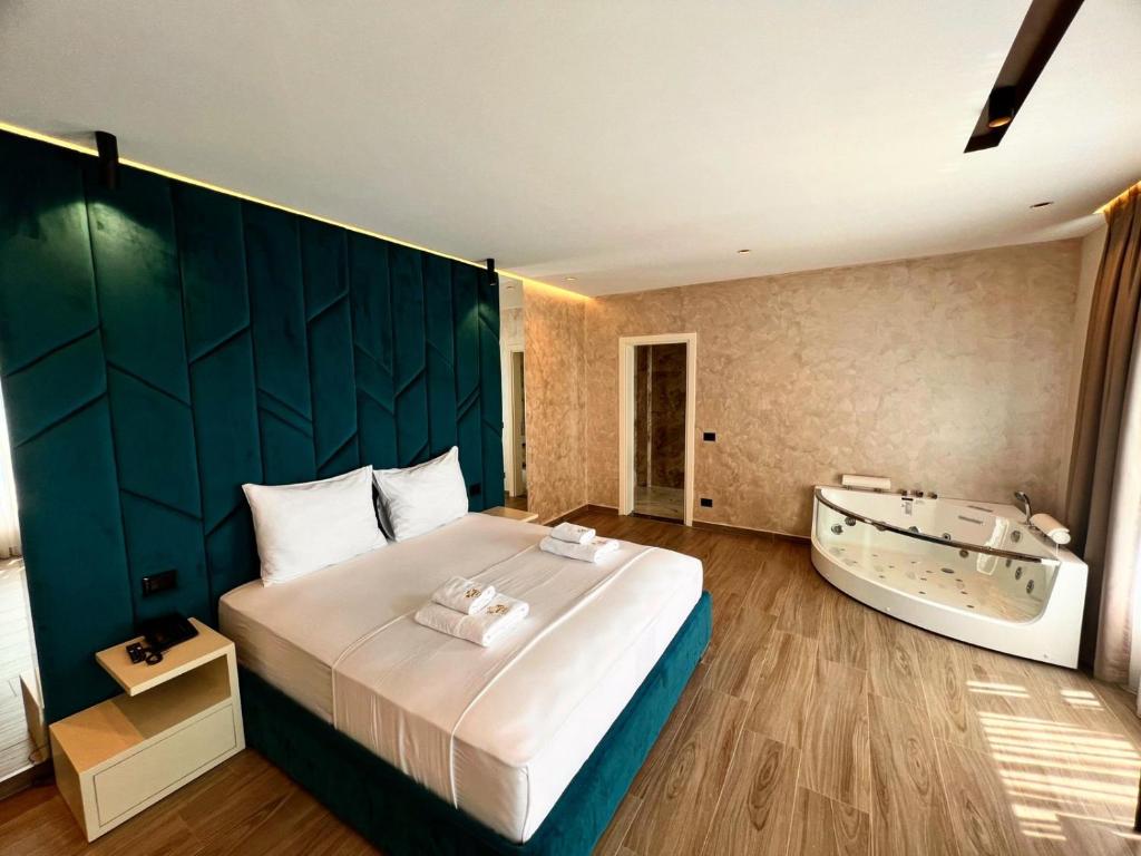 a bedroom with a large bed and a bath tub at Hotel LEON - Beach Front in Shëngjin