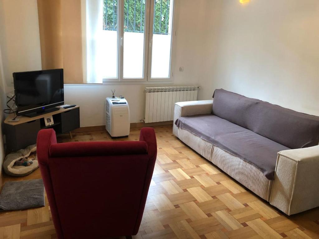 salon z kanapą i telewizorem w obiekcie Appartement Nice centre w Nicei