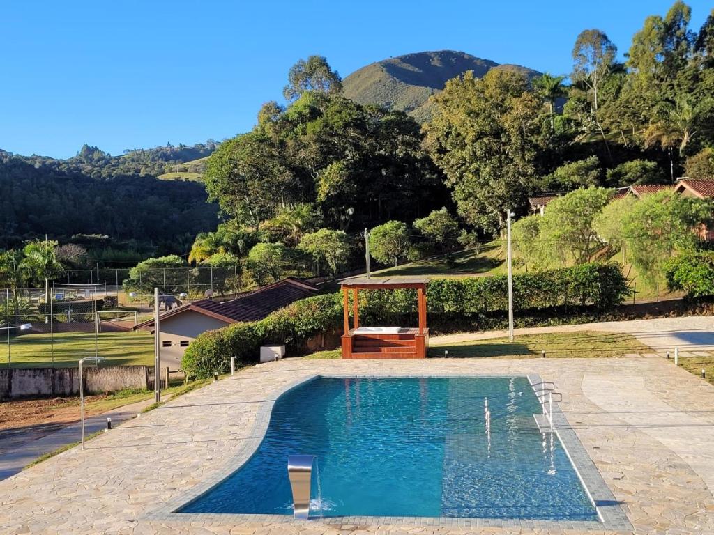 uma piscina com um gazebo num quintal em Pousada Thermas das Montanhas em Águas de Lindoia