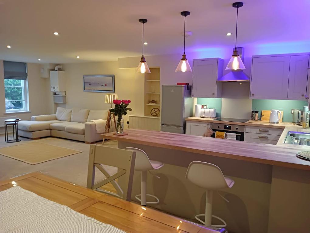 a kitchen and living room with purple lighting at Executive Barchester House Apartment in Salisbury