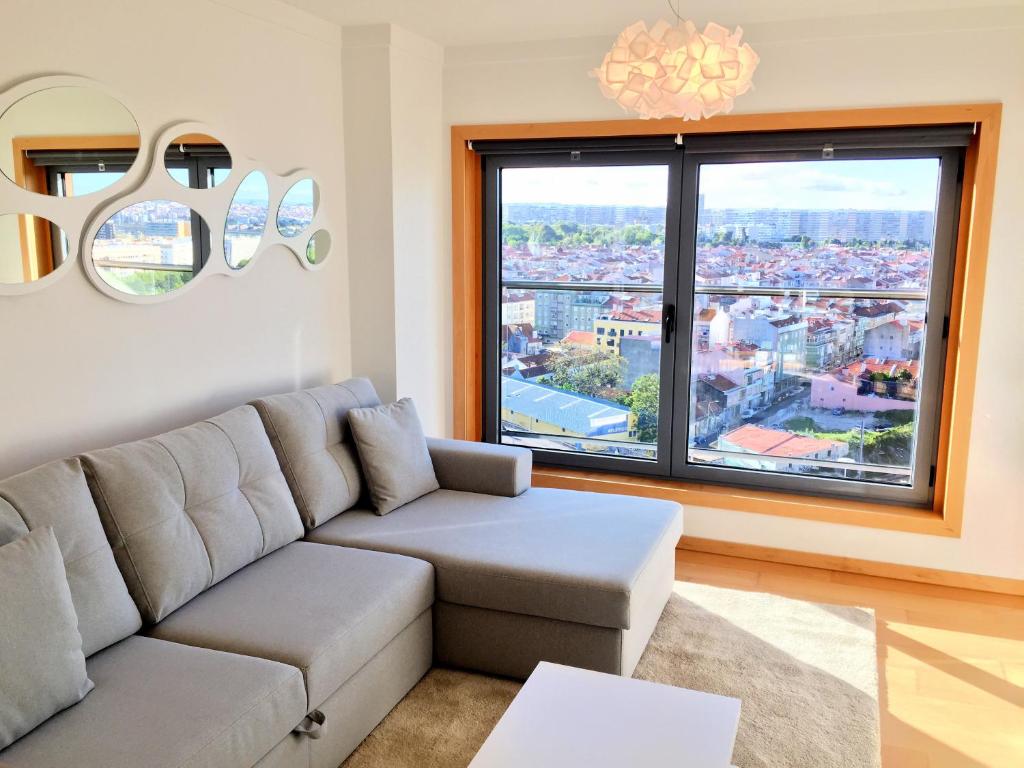 a living room with a couch and a large window at Finest Rentals - Expo Riverside in Lisbon