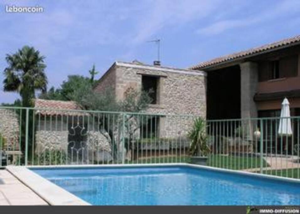 uma piscina em frente a uma casa em Villa Nova Raï du Mas des Fontaines - Jardin, piscine, terrasses 4 à 6 pers em Montagnac