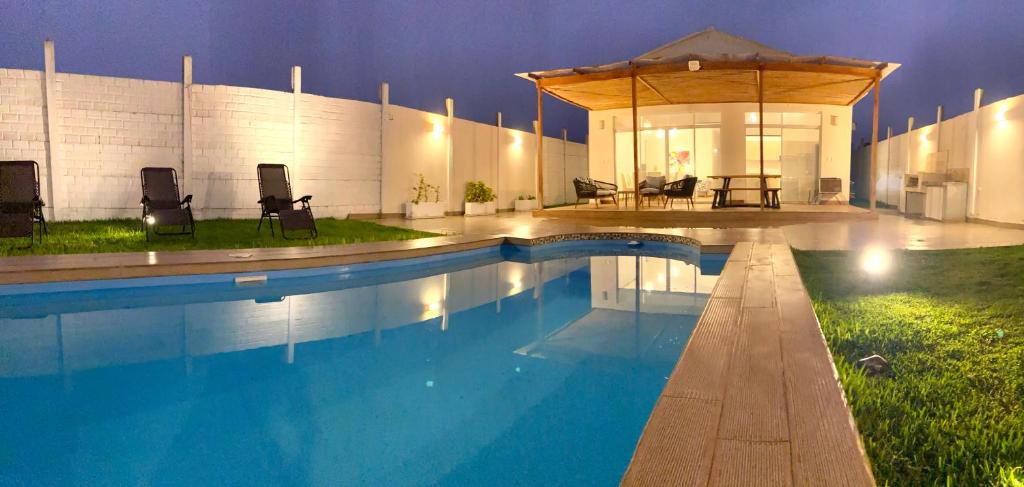 una piscina con sillas y un cenador en La Casa del Peregrino., en Miraflores