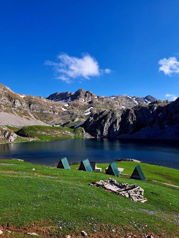 a group of tents in a field next to a lake at Mountain cottage Captain's Lake, Kapetanovo jezero in Kolašin