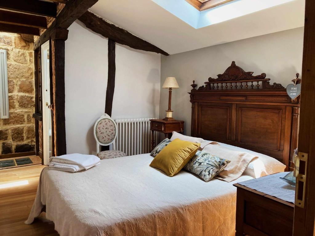 a bedroom with a large bed with a wooden headboard at Casa familia La Casa de Quintanilla 2 in Aguilar de Campóo