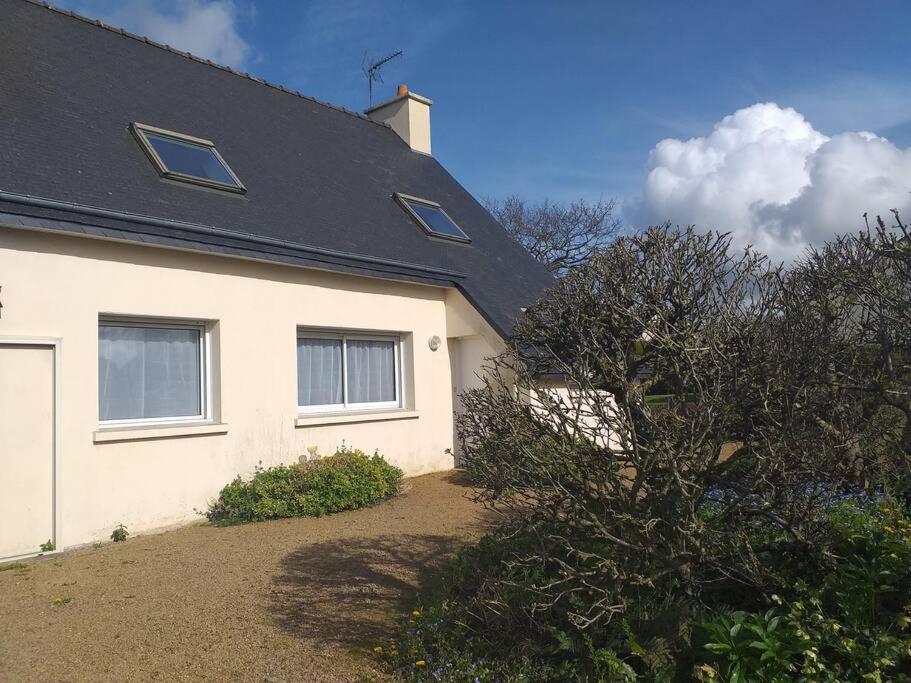 a white house with a black roof at Maison avec jardin clos dans cité de caractère in La Roche-Derrien