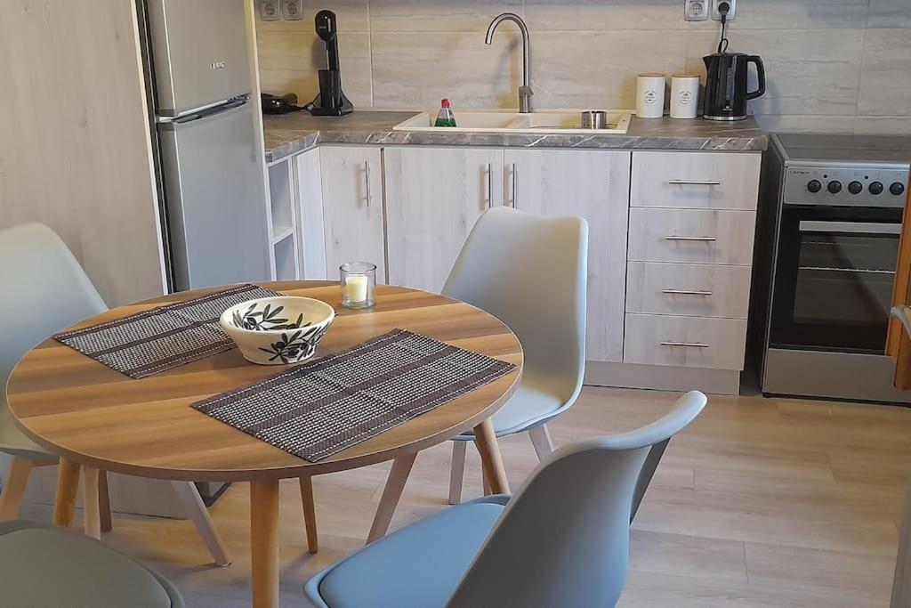 een keuken met een houten tafel en stoelen en een keuken met een wastafel bij 4 Season Cozy Home in Samothráki