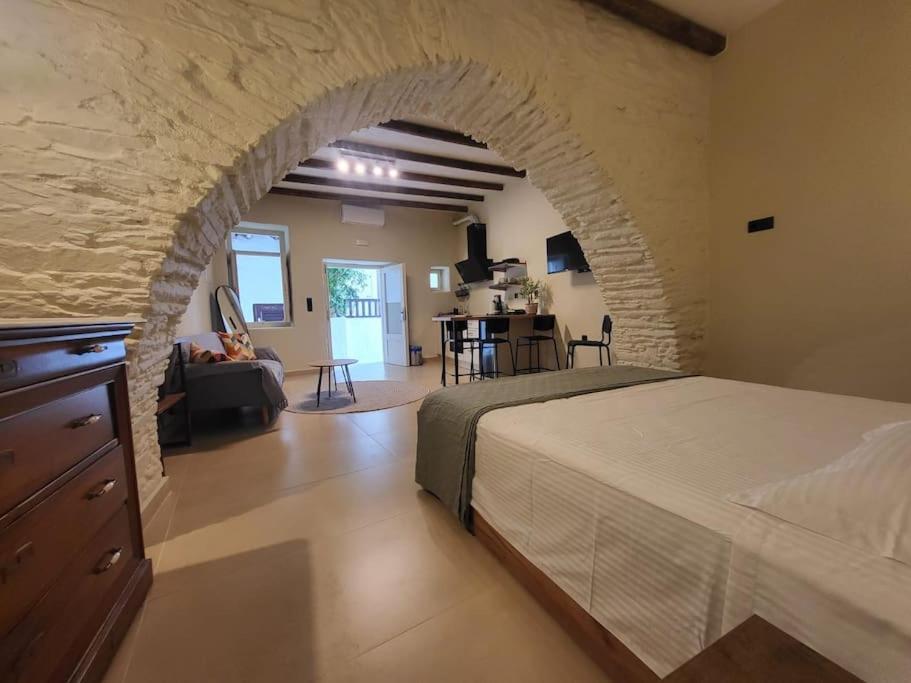 a bedroom with a bed and a stone wall at Coucou Boutique Studio in Ios Chora