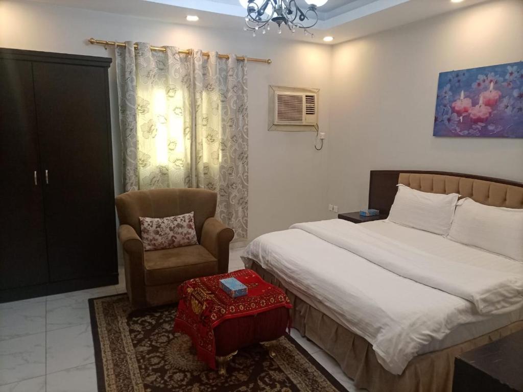 a bedroom with a bed and a chair at روائع الأحلام للاجنحة الفندقية in Jeddah