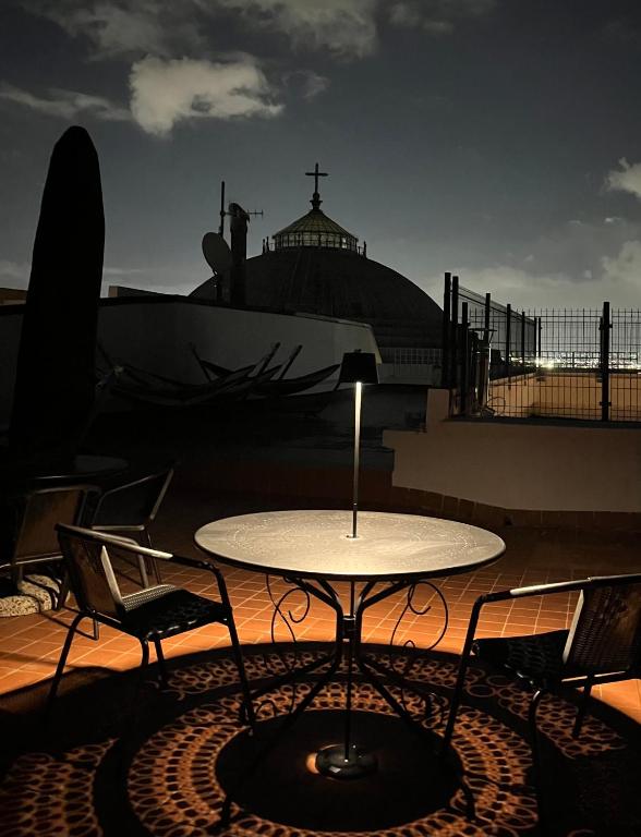 a table and chairs on a balcony with a church at Lucullo's Rooftop in Naples