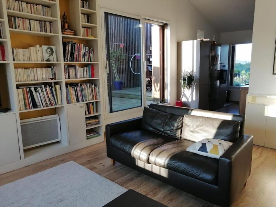 - un salon avec un canapé en cuir et des étagères dans l'établissement Attique vue mer et campagne, la plage à pied, à Saint-Jean-de-Luz