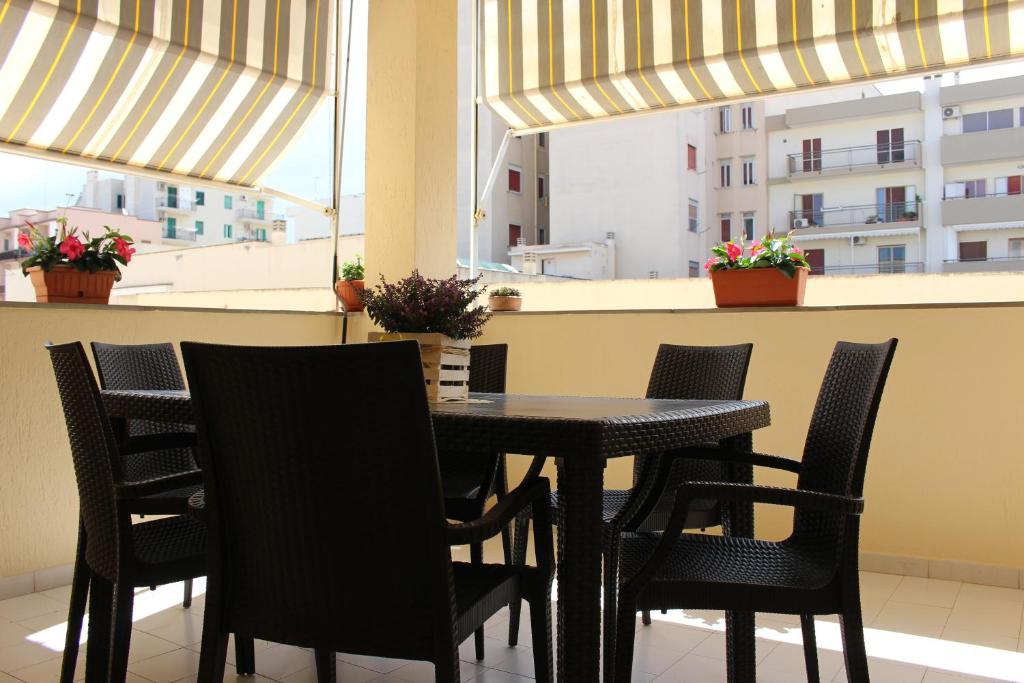 a black table and chairs in a room with windows at Maison Carmela in Monopoli