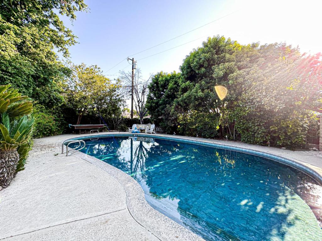a swimming pool with blue water in a yard at Charming 1 BR Poolside Retreat - Lou2-Bur in Burbank