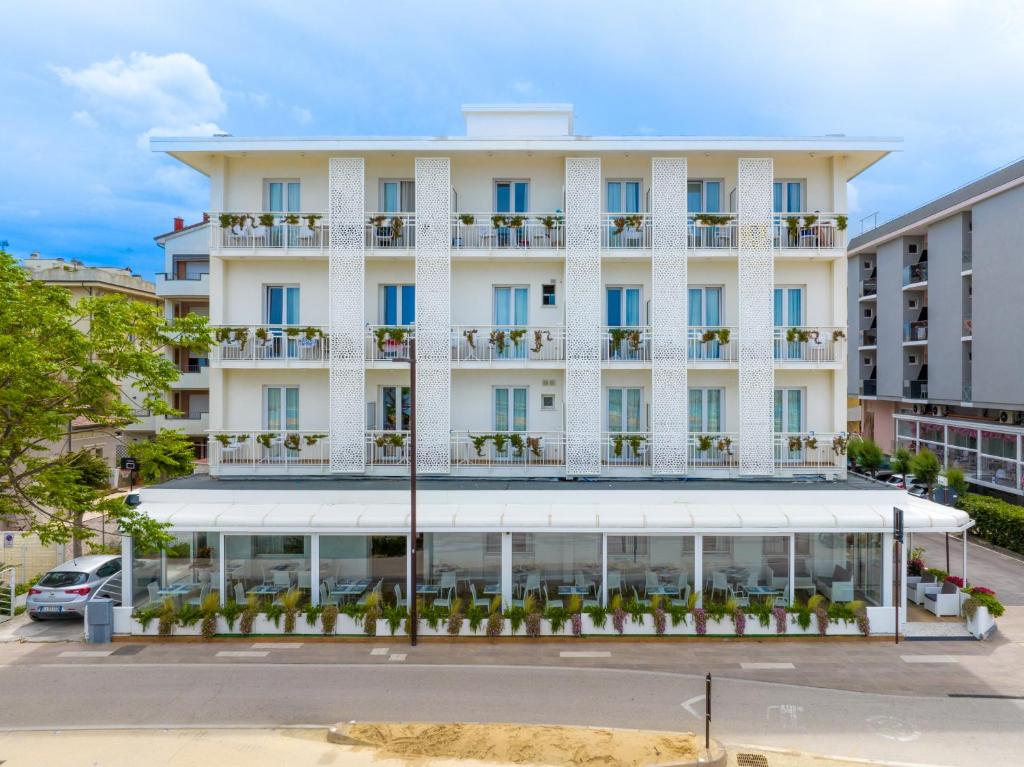 un hôtel avec un grand bâtiment blanc dans l'établissement Hb Hotels Orchidea Blu, à Rimini