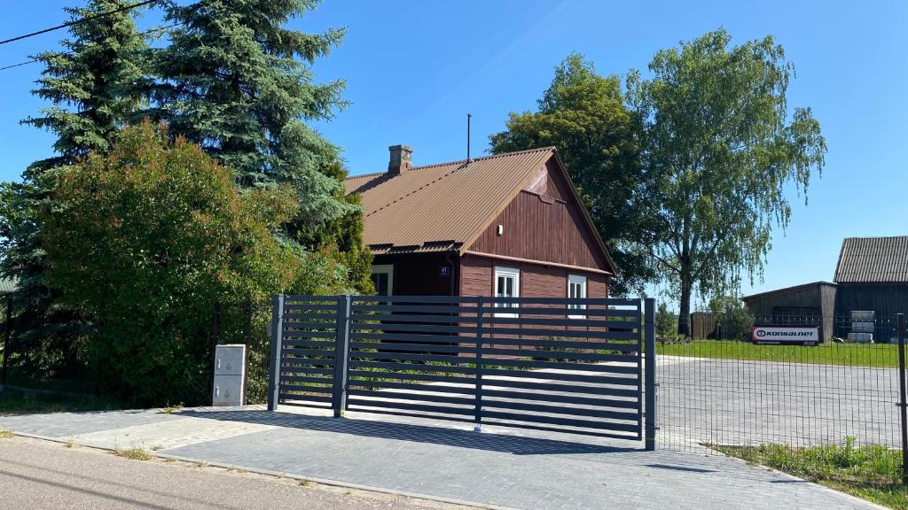 a fence in front of a building with a house at Siedlisko Rozalin 