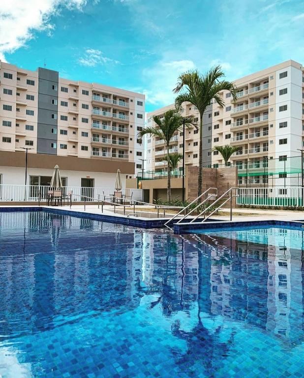 a large swimming pool in front of some buildings at Aruana Azul 502 - Apto com AR, PISCINA, Varanda Integrada - Aluguel por Temporada in Aracaju