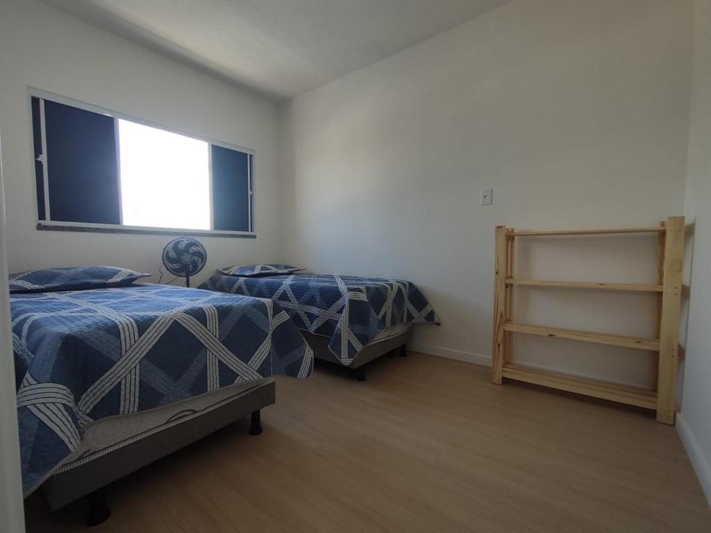 um quarto com 2 camas e uma janela em Aruana Azul 502 em Aracaju