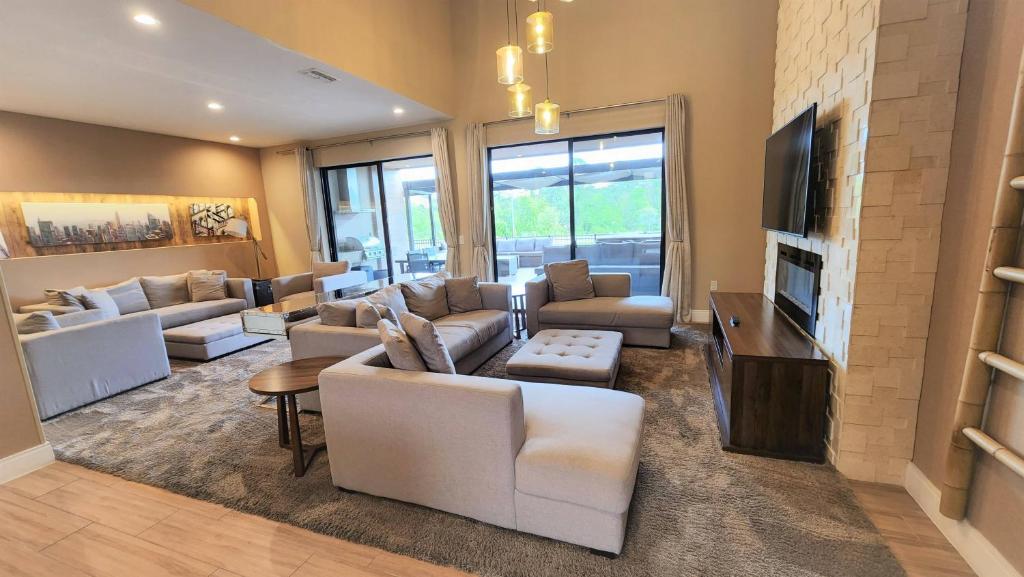 een woonkamer met witte meubels en een televisie bij 3053 Magic Village 3 suites jacuzzi BBQ 6min Disney in Orlando