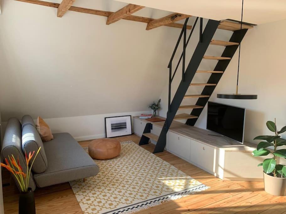 ein Wohnzimmer mit einem Sofa und einer Treppe in der Unterkunft Ostseeloft in Flensburg