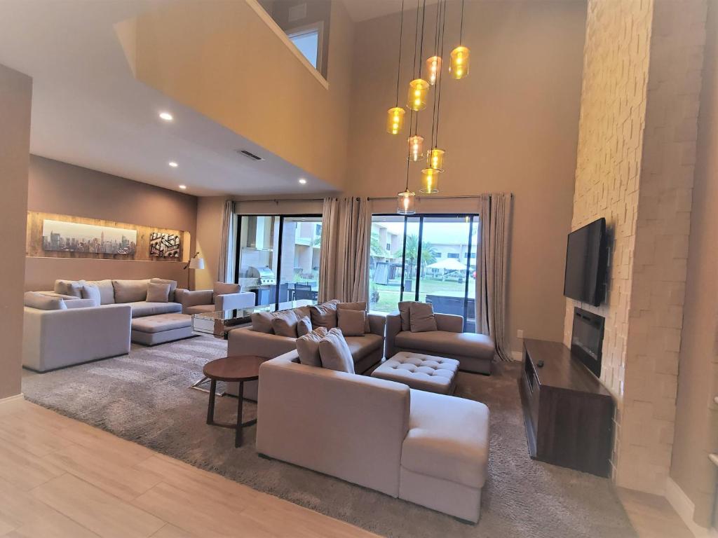 a living room with white couches and a tv at 7564 Magic Village luxury jacuzzi bbq 6min Disney & 192 in Orlando