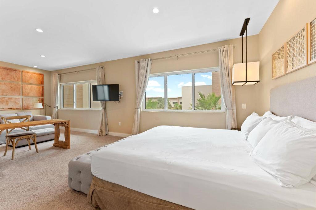 a bedroom with a large white bed and a table at 7462 Magic Village 8guests 4suites near Disney and 192 in Orlando