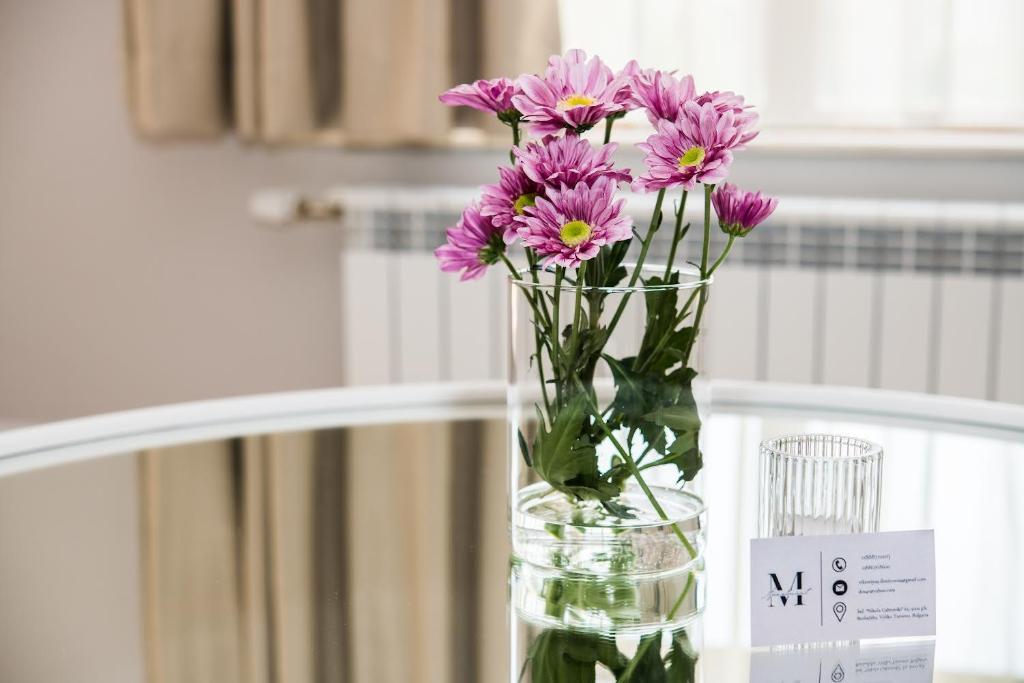 a vase filled with purple flowers sitting on a table at Luxury Martina apartment in Veliko Tŭrnovo