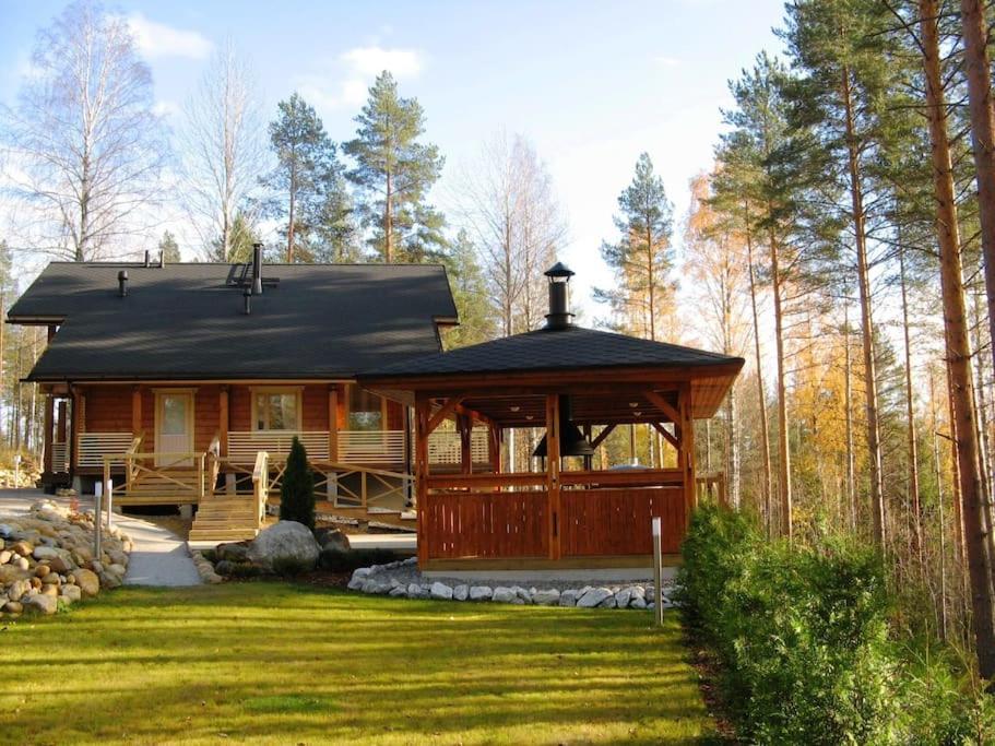 een huis met een tuinhuisje in het midden van een tuin bij Holiday Villa Kerimaa 18 in Savonlinna