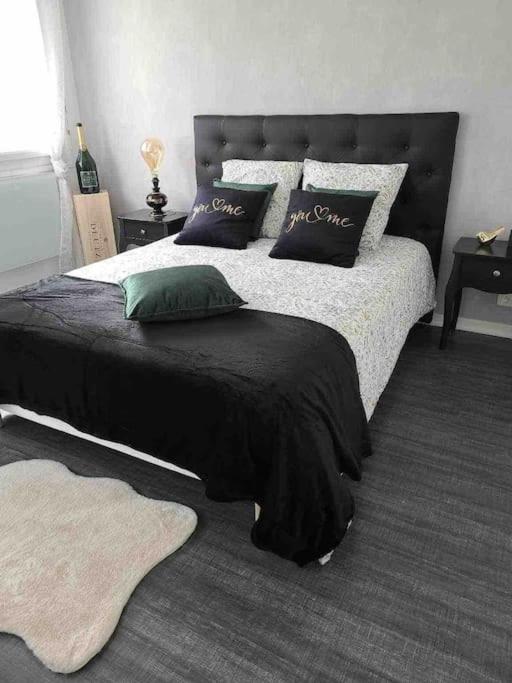 - une chambre avec un lit noir et blanc et des oreillers dans l'établissement AppartStudio « You & Me in Champagne », à Épernay