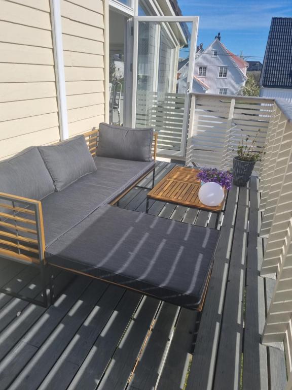 a patio with a couch on a deck at Cosy apartment on a quiet street in Kristiansand