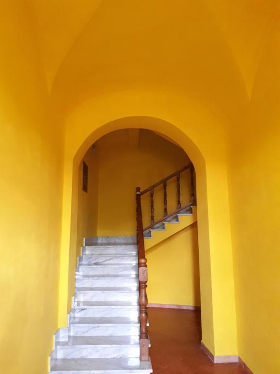 uma escada num quarto amarelo com uma parede amarela em Casa Assunta em Corvara