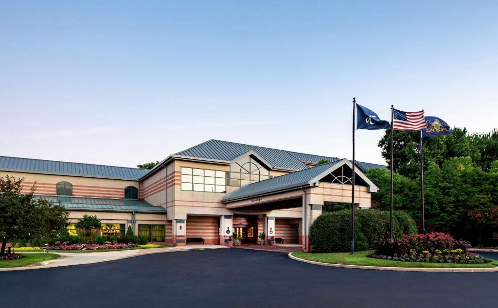 un edificio de oficinas con dos banderas delante en The Desmond Hotel Malvern, a DoubleTree by Hilton, en Malvern