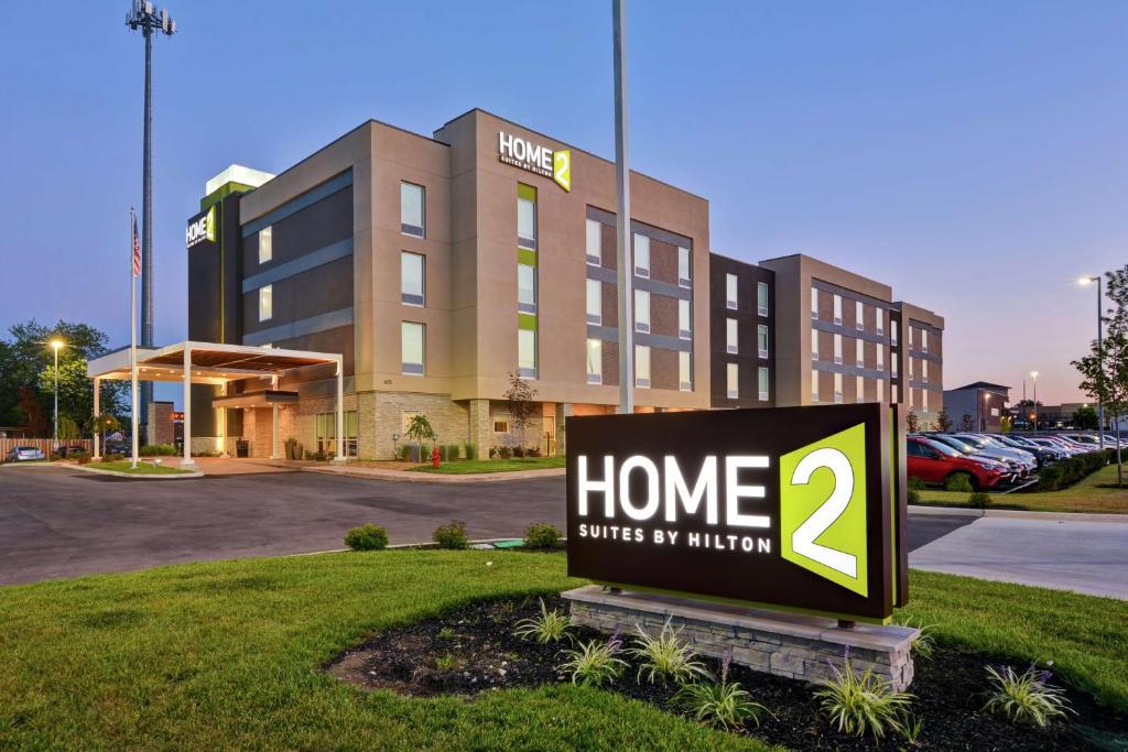 a sign in front of a building with a home smiles by autism at Home2 Suites By Hilton Dayton Vandalia in Dayton