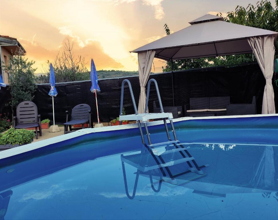Sotoserrano的住宿－Casa Carla，一个带椅子和遮阳伞的游泳池