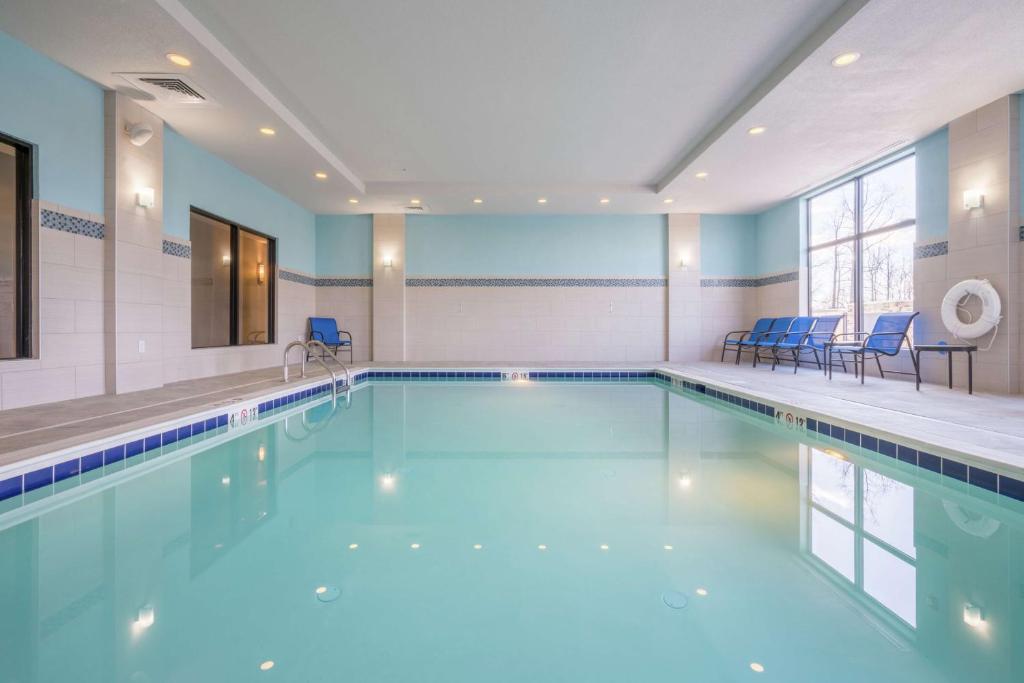 ein Pool mit blauen Stühlen in einem Gebäude in der Unterkunft Hampton Inn &amp; Suites Glenarden&#47;Washington DC in Largo