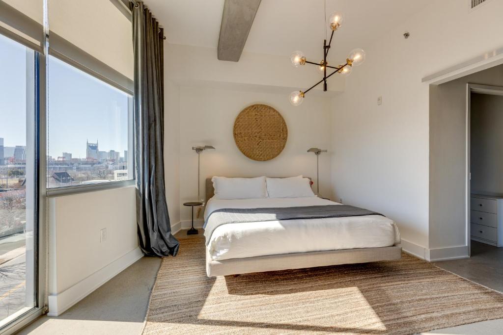 Un dormitorio con una cama y una ventana grande. en Amazing 2 Bd 4th floor condo with spectacular views, en Nashville