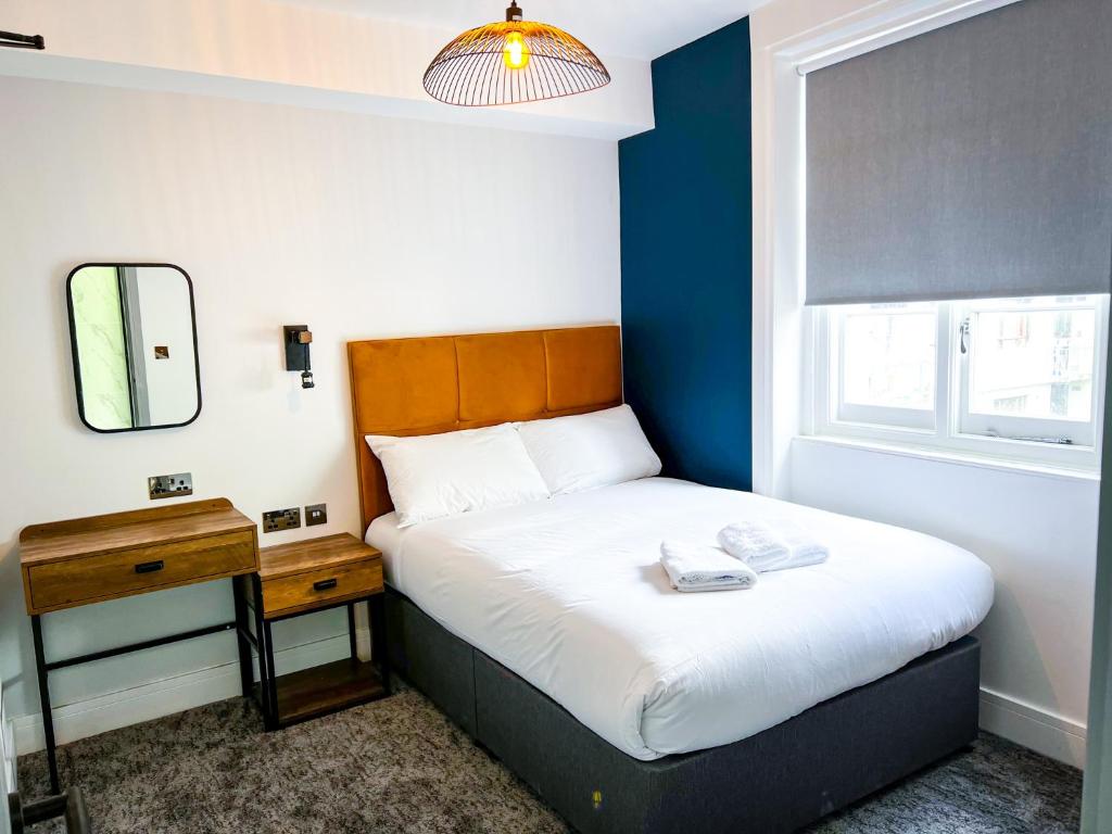a small bedroom with a bed and a mirror at Argo Hotel - Kings Cross in London