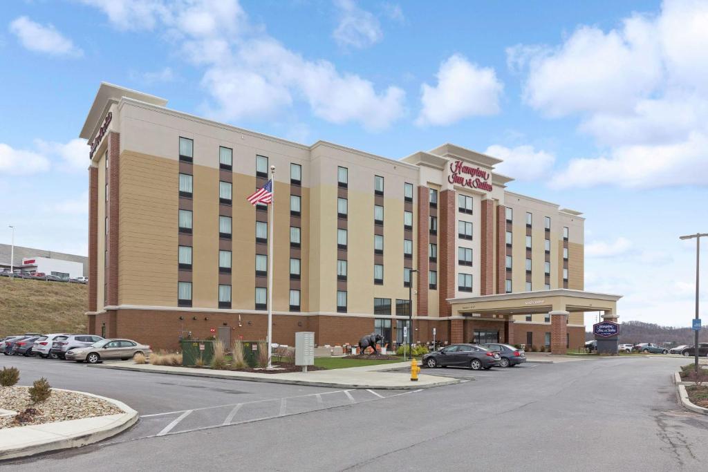 a hotel building with an american flag in front of it at Hampton Inn & Suites Morgantown / University Town Centre in Morgantown