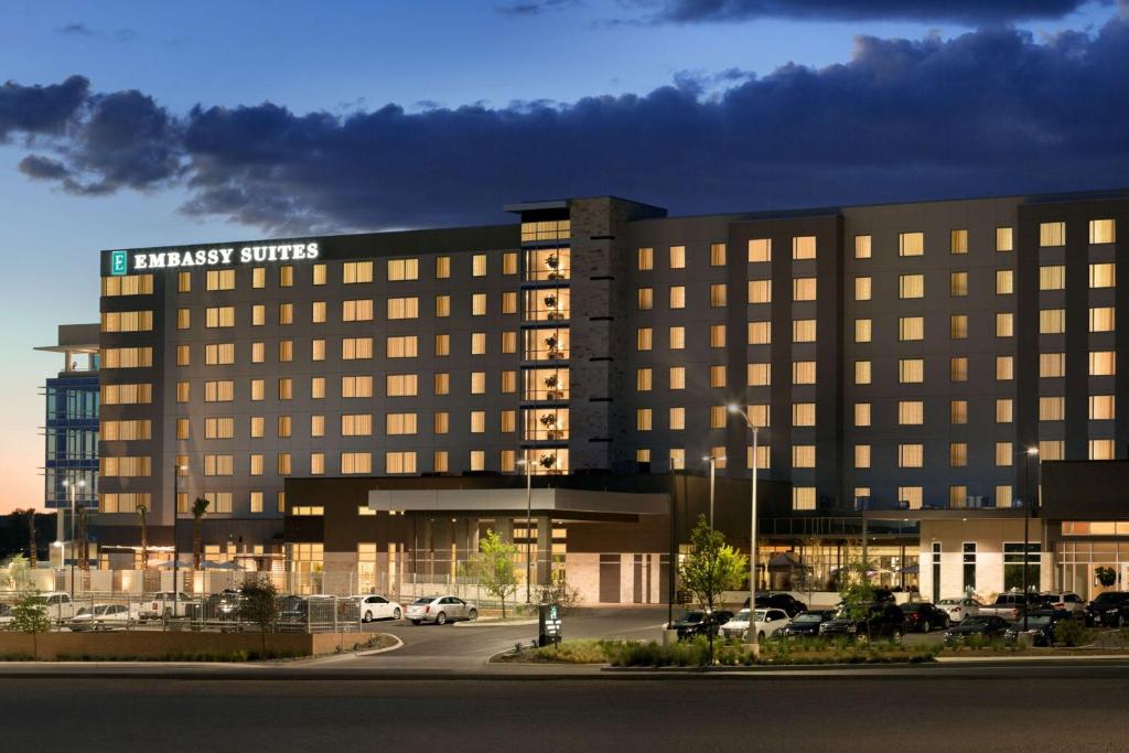 een groot gebouw met een parkeerplaats ervoor bij Embassy Suites By Hilton San Antonio Landmark in San Antonio