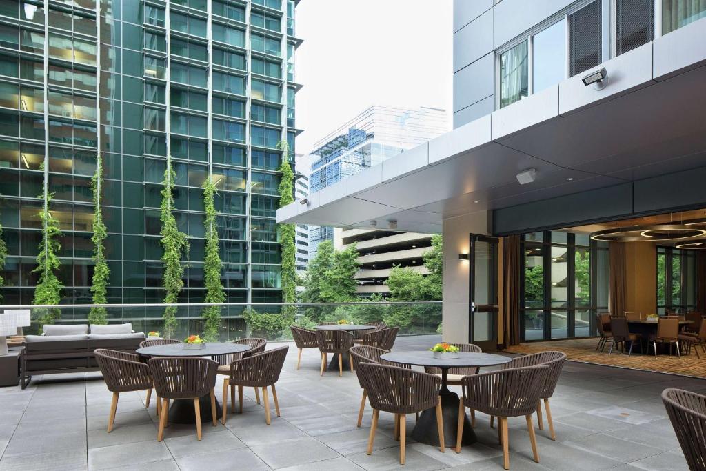 a patio with tables and chairs and a building at The Porter Portland, Curio Collection By Hilton in Portland