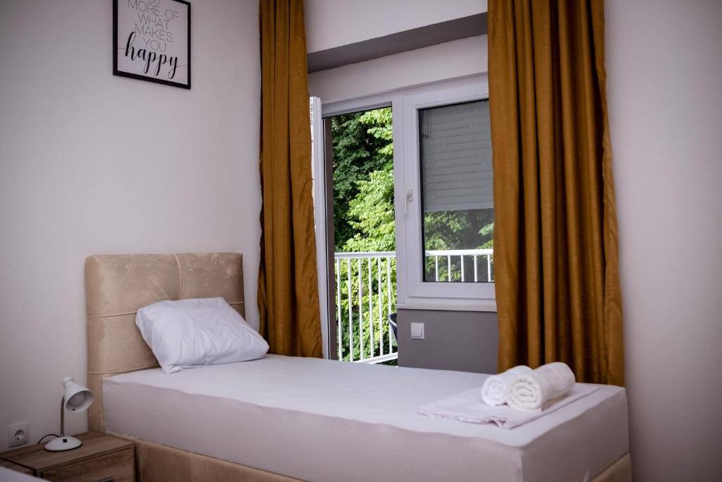 een slaapkamer met 2 bedden voor een raam bij Apartment Stone Mostar in Mostar
