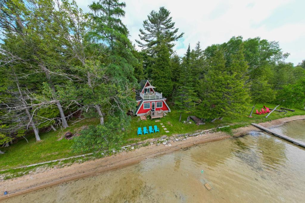 een luchtzicht op een huis aan de oever van een rivier bij Cozy Deer Lake Cabin, 3 Mi to Boyne Mtn Resort! in Boyne City