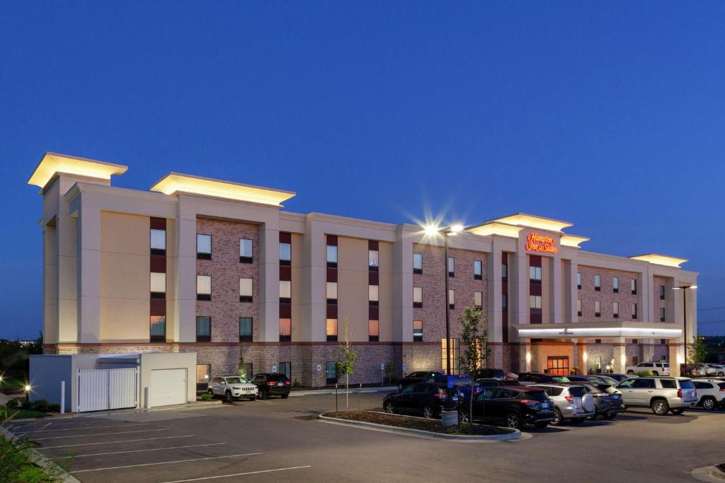 um hotel com carros estacionados num parque de estacionamento em Hampton Inn & Suites Overland Park South em Stanley