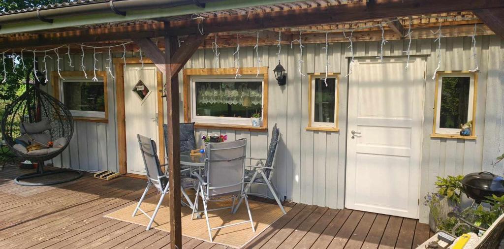 ein Haus mit einer Terrasse mit einer weißen Tür und Stühlen in der Unterkunft Saviaugu majake Põlvamaal in Kärsa
