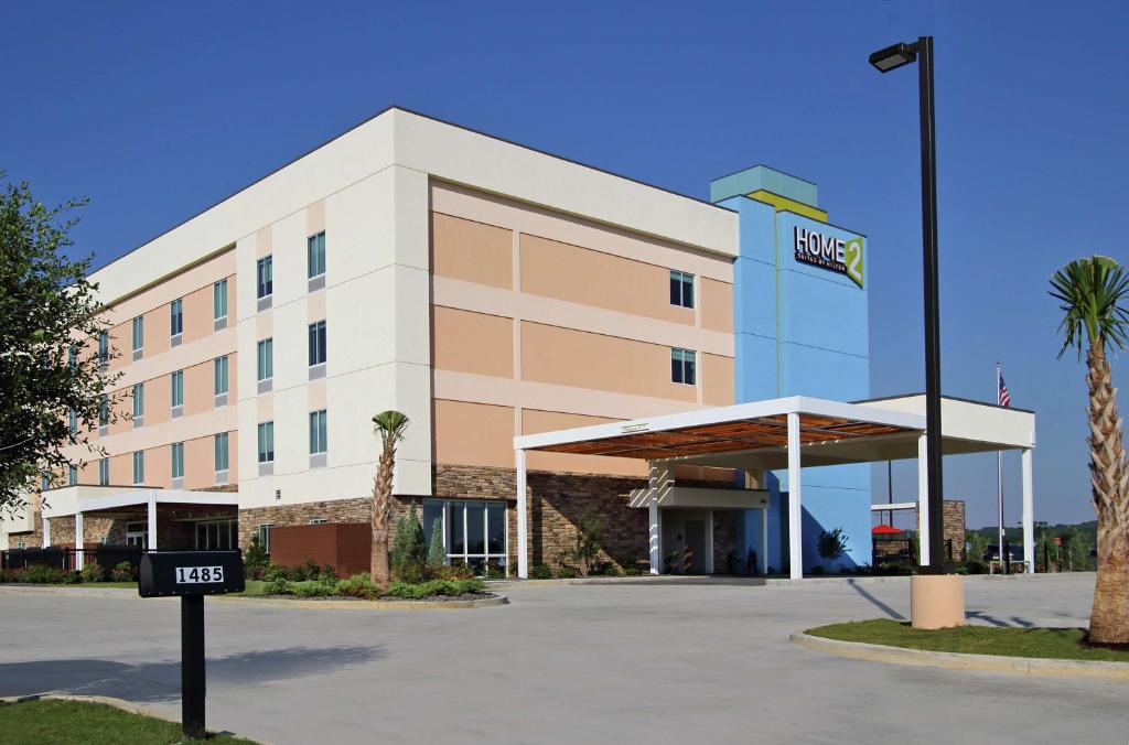 un edificio de oficinas con un cartel de hotel delante en Home2 Suites by Hilton Mobile I-65 Government Boulevard en Mobile