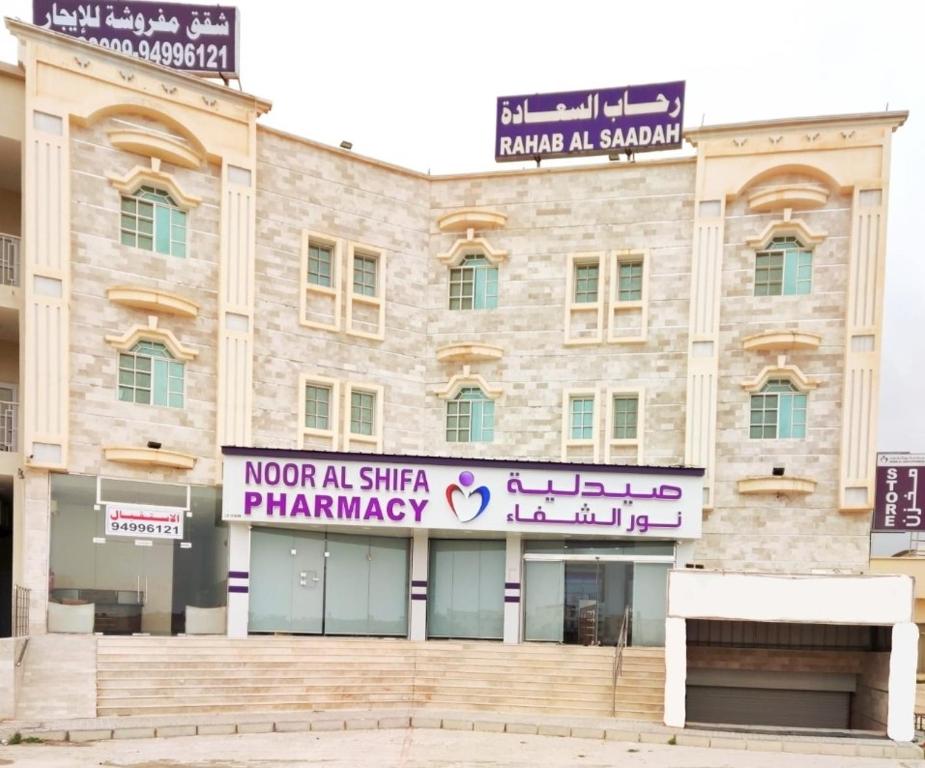 ein Gebäude mit einem Schild, das Notizbuch oder Apotheke liest in der Unterkunft رحاب السعاده rehab alsaadah apartment in Salalah