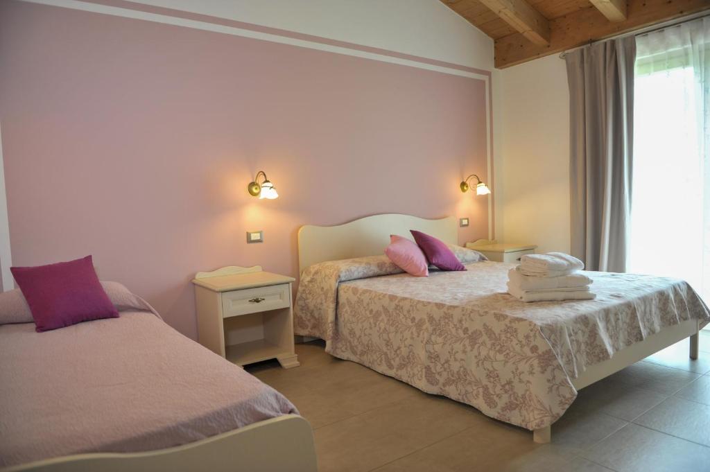 a bedroom with two beds and a window at Paradiso degli Ulivi B&B in Peschiera del Garda