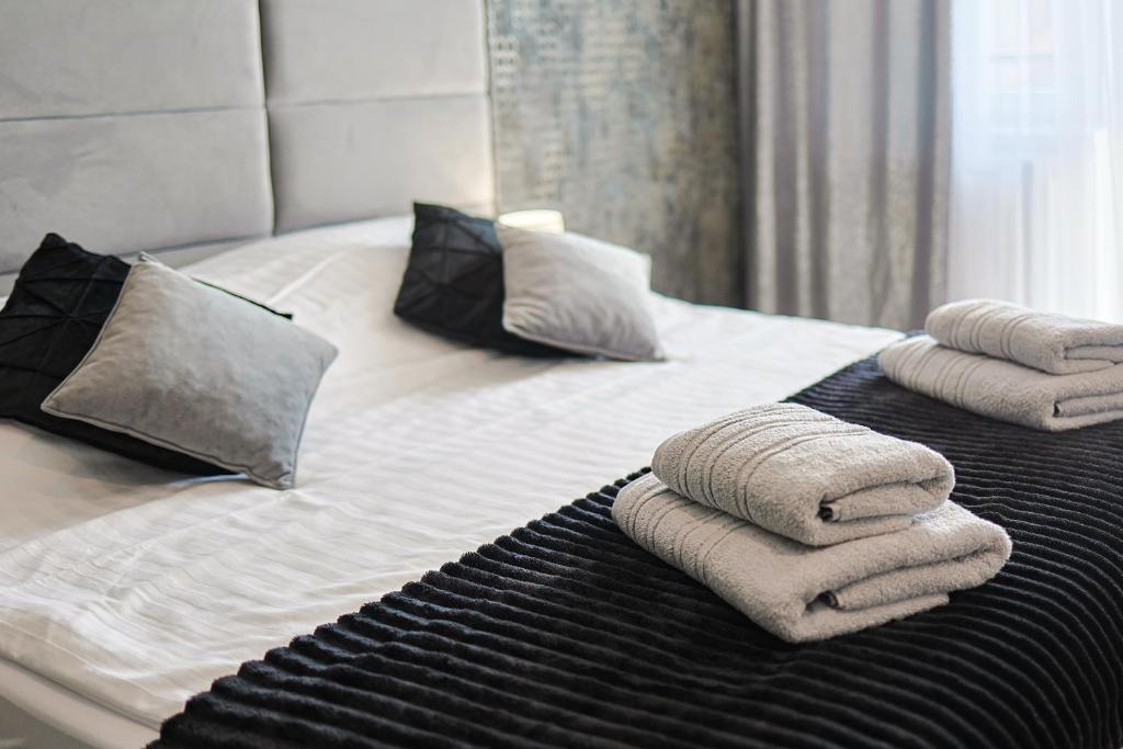 łóżko z ręcznikami i poduszkami w obiekcie AURORA JAROSŁAWIEC w mieście Jarosławiec
