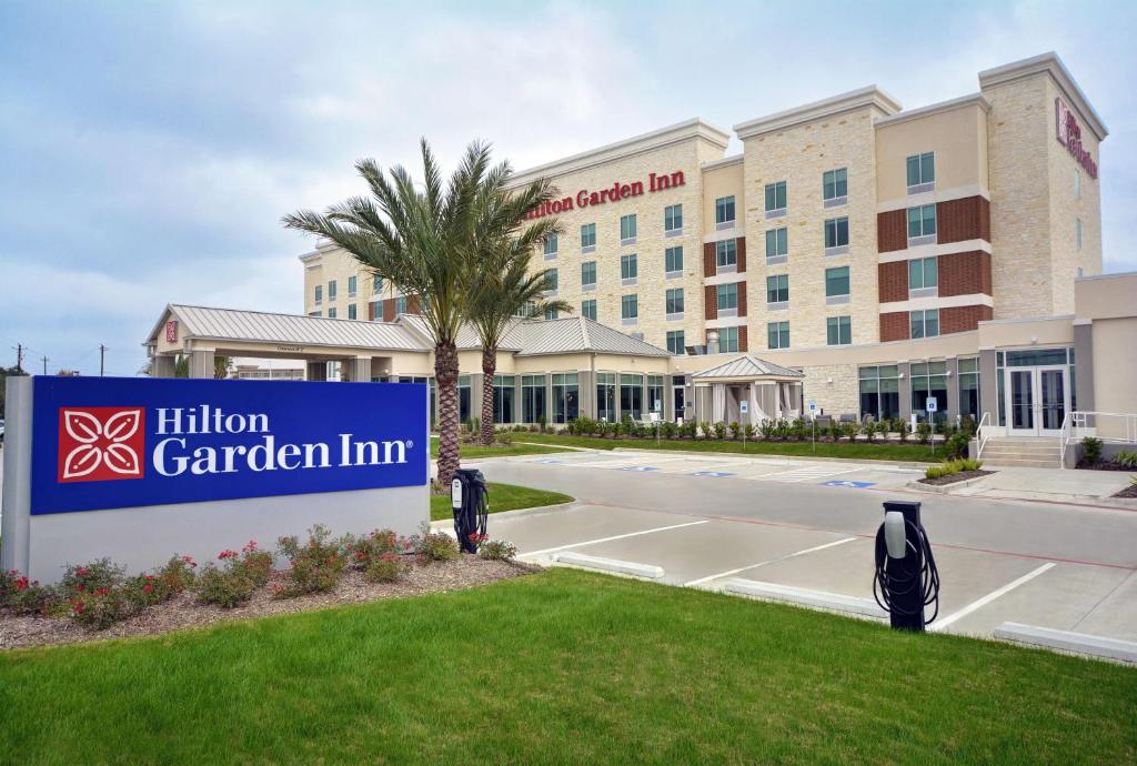 ヒューストンにあるHilton Garden Inn Houston Hobby Airportの建物前の看板のあるホテル