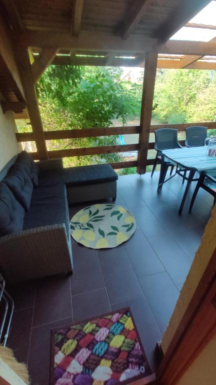 a screened in porch with a couch and a table at Rigó Nyaralóház in Lakitelek